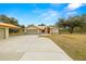 House exterior with attached garage and a large driveway at 18010 Okeene Dr, Hudson, FL 34667