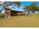 Rustic wooden outbuildings with a covered area and fenced yard at 18010 Okeene Dr, Hudson, FL 34667