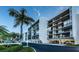 White building exterior, palm trees, and ample parking at 19111 Vista Bay Dr # 304, Indian Shores, FL 33785