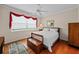 Main bedroom with wood floors, a ceiling fan, and a window with red curtains at 1933 Sterling Glen Ct, Sun City Center, FL 33573