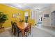 Bright dining area with a yellow accent wall and wood table at 1933 Sterling Glen Ct, Sun City Center, FL 33573