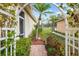 Pathway to villa entrance, featuring a charming arch and lush greenery at 1933 Sterling Glen Ct, Sun City Center, FL 33573