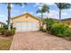 Front view of a single-story house with a two-car garage and a landscaped yard at 1933 Sterling Glen Ct, Sun City Center, FL 33573