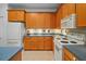 Modern kitchen with wood cabinets, white appliances, and a corner sink at 1933 Sterling Glen Ct, Sun City Center, FL 33573