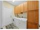 Bright laundry room with washer, dryer, and ample wood cabinets at 1933 Sterling Glen Ct, Sun City Center, FL 33573