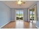 Light blue bedroom with wood floors and double sliding doors at 1950 Sterling Glen Ct, Sun City Center, FL 33573