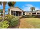 Back exterior of a house with a screened patio and manicured landscaping at 1950 Sterling Glen Ct, Sun City Center, FL 33573