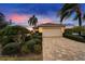 House exterior showcasing a paved driveway and manicured landscaping at dusk at 1950 Sterling Glen Ct, Sun City Center, FL 33573