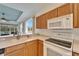 Kitchen features wood cabinets, white appliances, and a view of the backyard at 1950 Sterling Glen Ct, Sun City Center, FL 33573