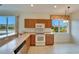 Kitchen with wood cabinets, white appliances, and a window at 1950 Sterling Glen Ct, Sun City Center, FL 33573