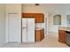 Kitchen boasts white refrigerator, wood cabinets, and pantry at 1950 Sterling Glen Ct, Sun City Center, FL 33573