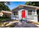 Gray house with red door, front yard, and concrete driveway at 2002 E Ellicott St, Tampa, FL 33610