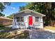 Gray house with red door, front yard, and concrete driveway at 2002 E Ellicott St, Tampa, FL 33610