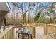 Wooden deck with a small table and chairs, overlooking a wooded area at 26451 Glenhaven Rd, Wesley Chapel, FL 33544