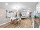 Bright dining area with white table and chairs, hardwood floors, and large artwork at 26451 Glenhaven Rd, Wesley Chapel, FL 33544