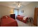 Guest bedroom with two twin beds, ceiling fan, and wood-look floors at 276 Rochester St, Spring Hill, FL 34609