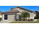 Front view of a single-story house with a garage and palm trees at 276 Rochester St, Spring Hill, FL 34609