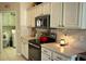 Kitchen with white cabinets, stainless steel appliances and adjacent laundry room at 276 Rochester St, Spring Hill, FL 34609