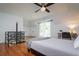 Upstairs bedroom with hardwood floors, private balcony access and ceiling fan at 2812 W Neptune St, Tampa, FL 33629