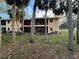 Ground-level view of condo building, featuring a screened patio and backyard at 3001 58Th S Ave # 701, St Petersburg, FL 33712