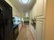 Long kitchen with white cabinets, black appliances, and ample storage at 3001 58Th S Ave # 701, St Petersburg, FL 33712