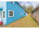 View of backyard with light blue house and detached garage at 3630 E North Bay St, Tampa, FL 33610