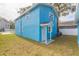 Newly constructed light blue home with a covered entry and small yard at 3630 E North Bay St, Tampa, FL 33610