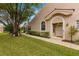 House exterior showcasing a walkway, landscaping, and a light-beige color scheme at 3838 Muirfield Ct, Palm Harbor, FL 34685