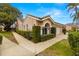 Two-story home with a walkway, lush greenery, and a two-car garage at 3838 Muirfield Ct, Palm Harbor, FL 34685