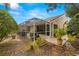 Home exterior showcasing a large screened patio and landscaping at 3838 Muirfield Ct, Palm Harbor, FL 34685