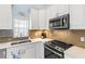 Well-equipped kitchen with stainless steel appliances and light-colored cabinets at 3838 Muirfield Ct, Palm Harbor, FL 34685