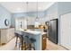 Modern kitchen with white cabinets, quartz countertops, and a breakfast bar at 3838 Muirfield Ct, Palm Harbor, FL 34685