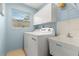 Laundry room with washer, dryer, utility sink, and white cabinets at 3838 Muirfield Ct, Palm Harbor, FL 34685