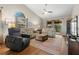 Bright living room featuring hardwood floors, a ceiling fan, and comfy seating at 3838 Muirfield Ct, Palm Harbor, FL 34685