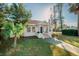 Front view of a white cottage with a terracotta tiled walkway, and a well-manicured lawn at 4056 18Th S Ave, St Petersburg, FL 33711