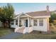 White cottage with a blue door, terracotta steps, and landscaping at 4056 18Th S Ave, St Petersburg, FL 33711