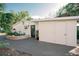 White home exterior with gray door, landscaping, and detached garage at 4056 18Th S Ave, St Petersburg, FL 33711