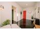 Bright hallway with dark wood floors and a vibrant orange door at 4056 18Th S Ave, St Petersburg, FL 33711