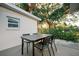 Small patio with black table and chairs set against a white building at 4056 18Th S Ave, St Petersburg, FL 33711