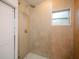 Walk-in shower with beige tile and white pebble floor at 4056 18Th S Ave, St Petersburg, FL 33711