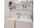 Laundry room with washer, dryer, and storage shelving at 4154 Pinelake Ln # 101, Tampa, FL 33618