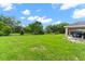 Spacious backyard with lush green grass and a covered patio at 4522 Gondolier Rd, Spring Hill, FL 34609