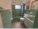 Retro bathroom with green tiled walls and bathtub at 504 Holly Ln, Brandon, FL 33510