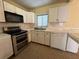 Galley kitchen with white cabinets and stainless steel appliances at 504 Holly Ln, Brandon, FL 33510