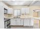 Well-lit kitchen with white cabinets, tile countertops, and modern appliances at 504 Holly Ln, Brandon, FL 33510