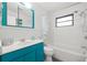 Bright bathroom with teal vanity, white tub and shower at 5243 27Th N Ave, St Petersburg, FL 33710