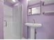 Purple bathroom with pedestal sink, shower, and floating shelves at 5243 27Th N Ave, St Petersburg, FL 33710