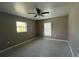 Well-lit bedroom with neutral walls, carpet, ceiling fan and two windows at 5352 Tangerine Dr, New Port Richey, FL 34652