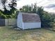 Tan shed with white door and brown roof in backyard at 5352 Tangerine Dr, New Port Richey, FL 34652