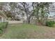 Large backyard with mature trees and a wooden fence at 553 Lake Hill Ln, Largo, FL 33771